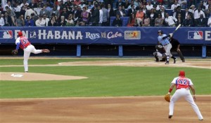 Tampa Bay Rays batman bats the ball as Presidents Obama and Castro watch during a baseball match between the Tampa Bay Rays and Cuba in Havana, Cuba, Tuesday March 22, 2016. The crowd roared as U.S. President Barack Obama and Cuban President Raul Castro entered the stadium and walked toward their seats in the VIP section behind home plate. It's the first game featuring an MLB team in Cuba since the Baltimore Orioles played in the country in 1999. (AP Photo/Ramon Espinosa)