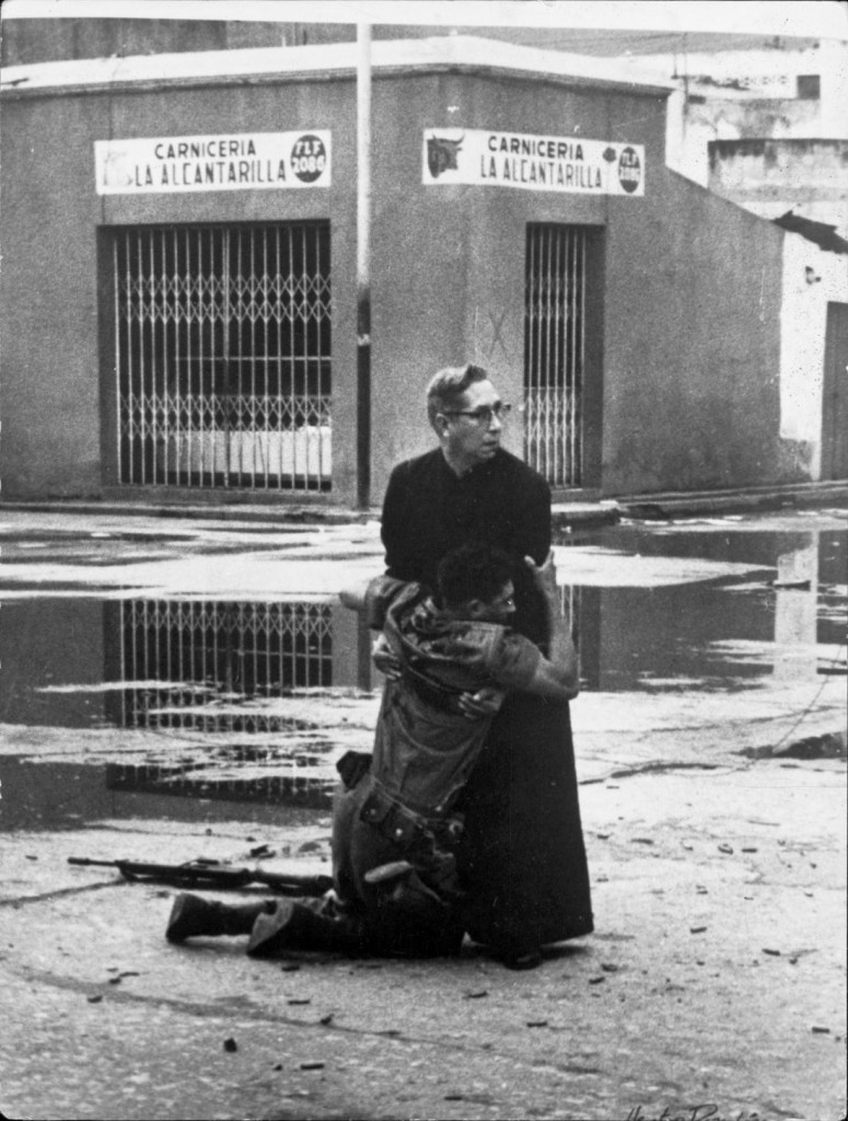 1962: Un padre da la última bendición a un soldado herido de muerte durante el levantamiento contra el presidente venezolano Rómulo Bétancourt. Foto: Héctor Rondón Lovera. 