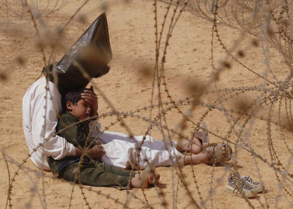 2003: Un hombre iraquí, prisionero del campo base 101st Airborne Division del ejército estadounidense, consuela a su hijo de 4 años. Foto: Jean-Marc Bouju.